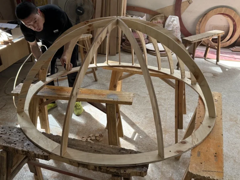 Craftsman building a wooden dome frame for a themed playground