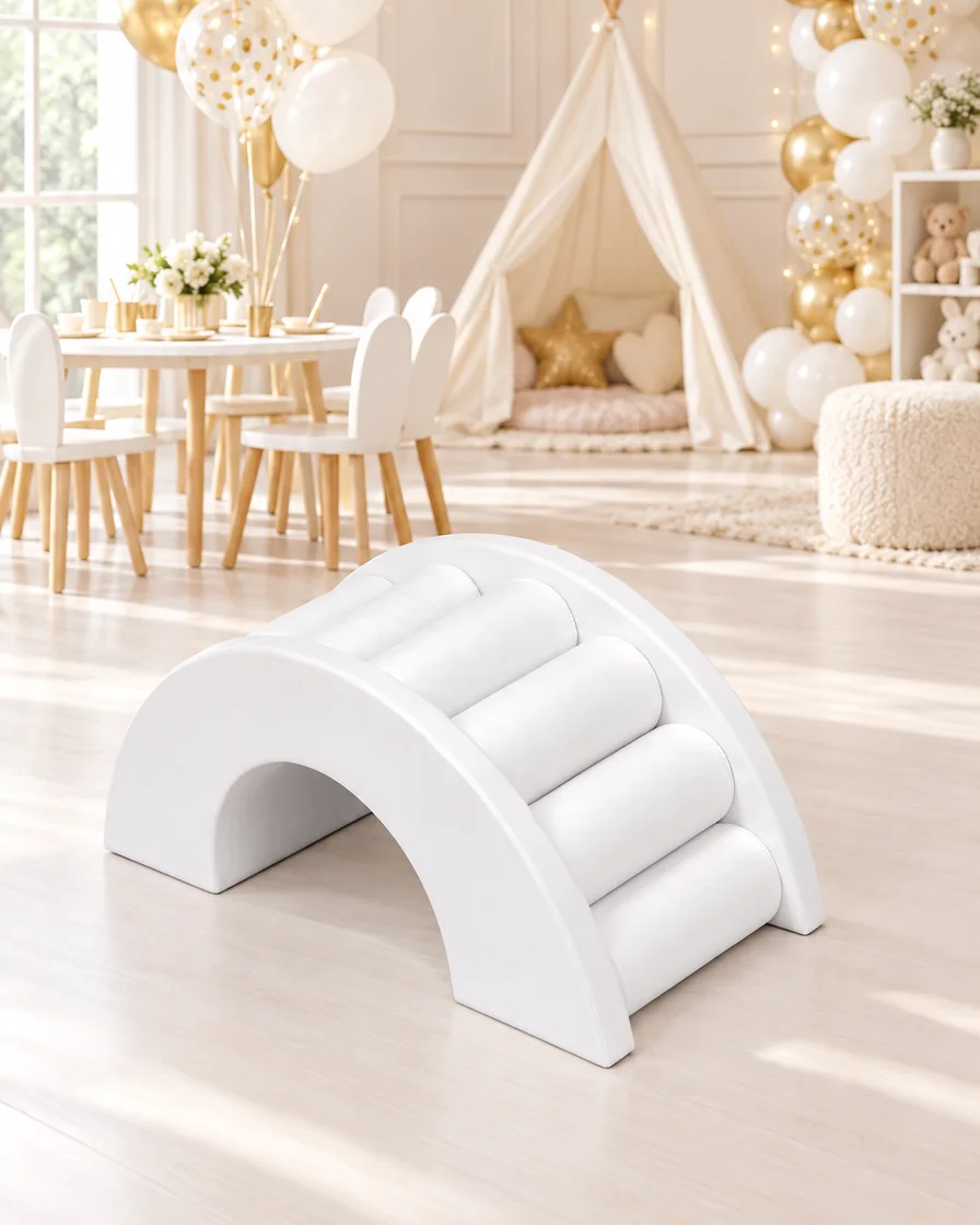 White rainbow Roller Soft Play Bridge in a kids party room indoor playground