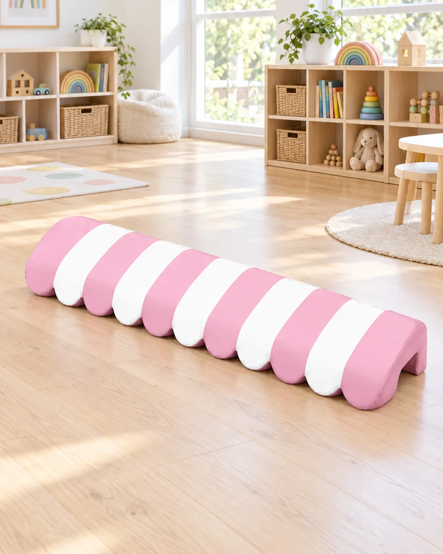 PlayCurator Scalloped Awning Soft Play Tunnel — Pink Stripe & Pastel Stripe 1 Pink Stripe & Pastel Stripe scalloped Awning Soft Play Tunnel in a kindergarten playroom indoor playground